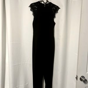 Beautiful Iris black jumpsuit with lace around the sleeves of the arm.